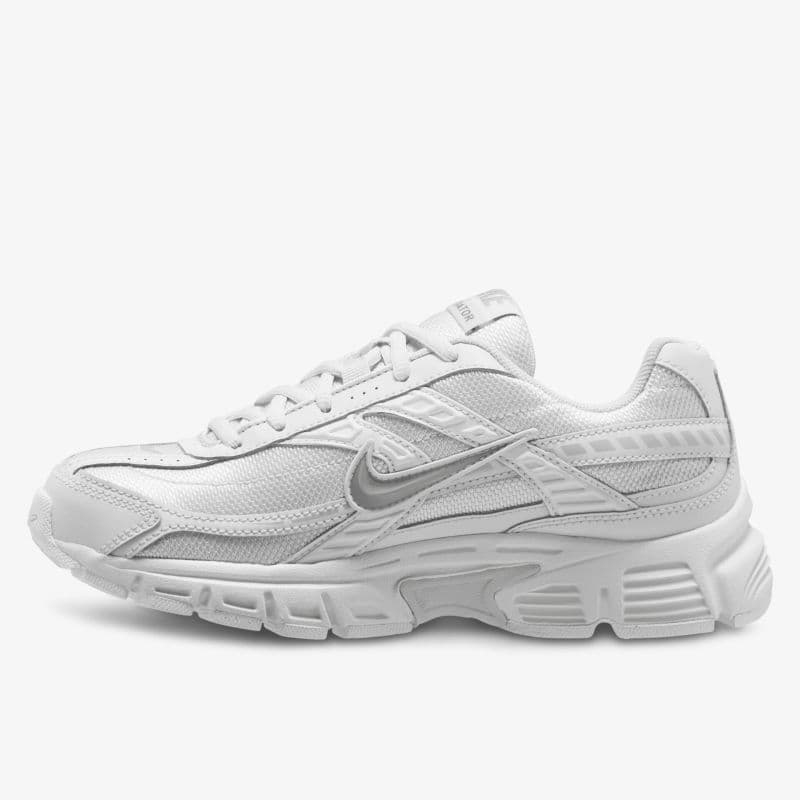 A white athletic sneaker with mesh panels, textured sole, and distinctive branding on the side, viewed from the side on a plain background.