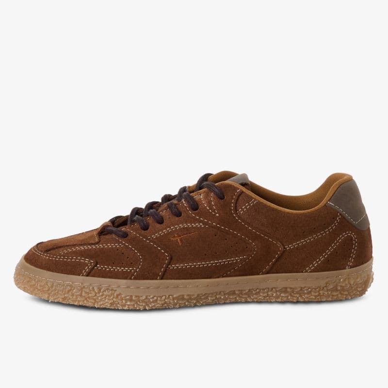Brown suede sneaker with white stitching, dark brown laces, and a textured beige sole on a white background.